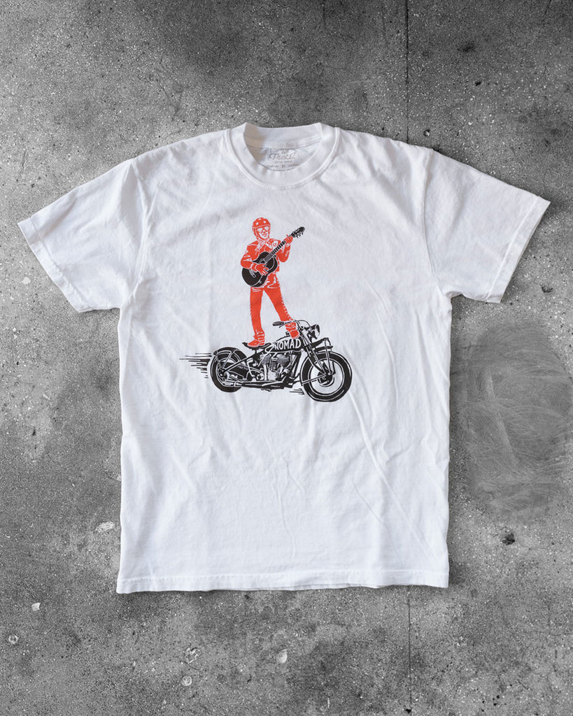 White FRET12 Mariachi Rider Tee showcasing a bold graphic of the legendary Mariachi Rider standing on a motorcycle, strumming a guitar, set against a clean, minimal backdrop.