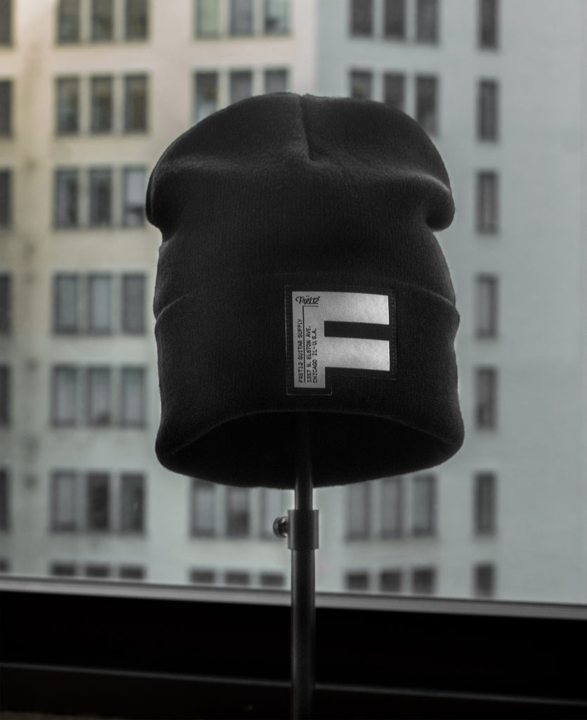 A classic black beanie with the FRET12 FAT F silk tag sewn on the front.